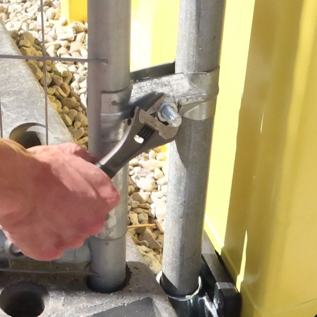Securing a fence panel to a shipping container using a Domino Clamp
