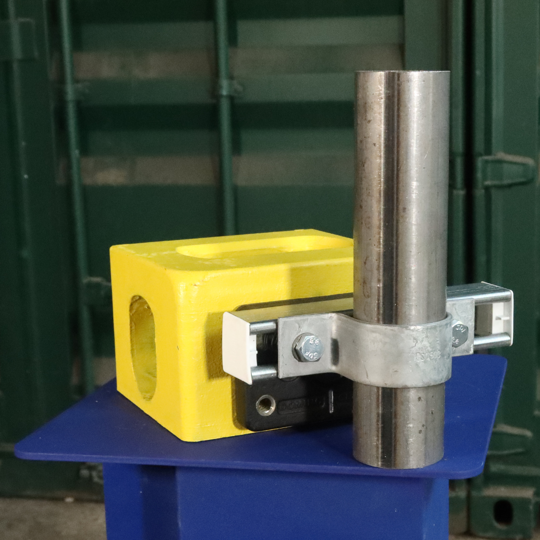 Unistrut Pipe Clamp size F 60mm attached to a shipping container corner casting