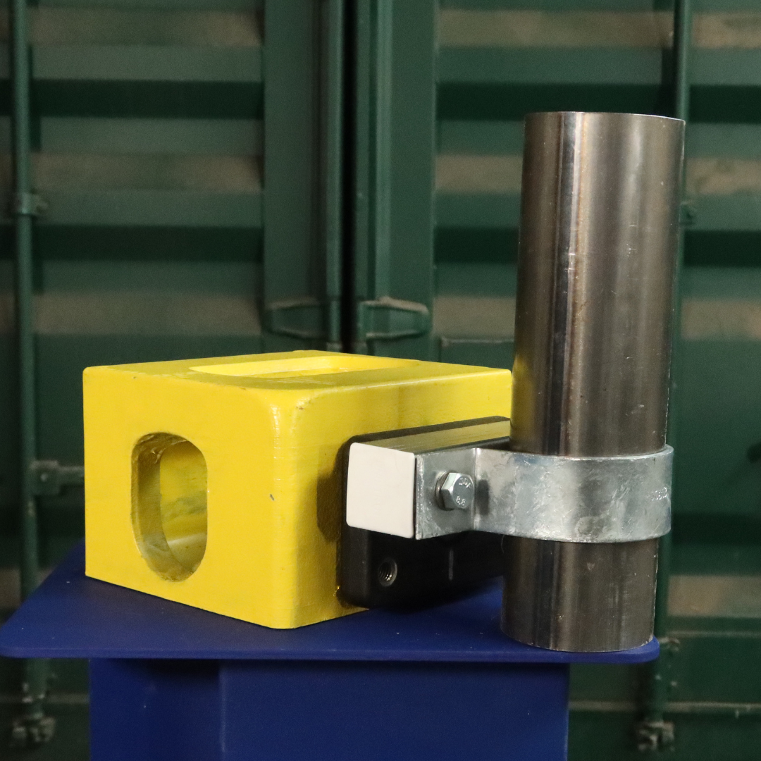 Unistrut Pipe Clamp size G 76mm attached to a shipping container corner casting