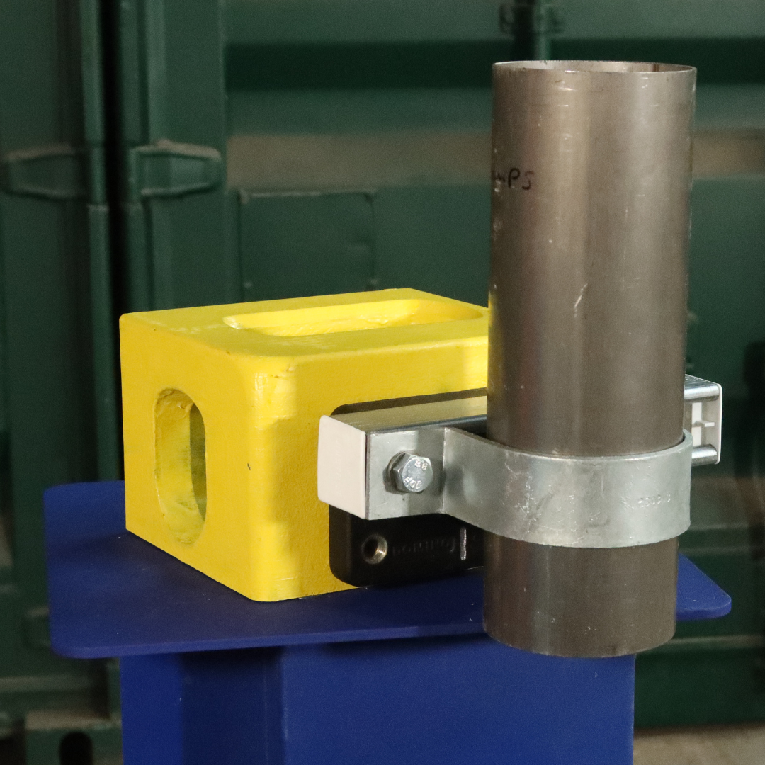 Unistrut Pipe Clamp size H 89mm attached to a shipping container corner casting