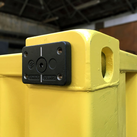 Side view of Domino Clamp attached to a shipping container